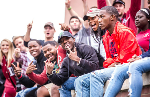 Students in stands cheer during football game