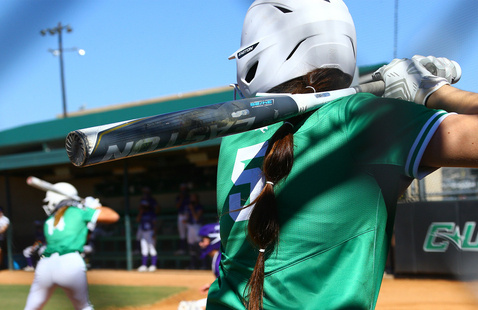 Mean Green Softball batter in the batter's box in the foreground, and a Mean Green Softball batter at the plate in the background.