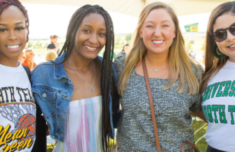 A photo of four graduating students.