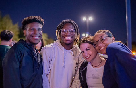 four students standing together smiling