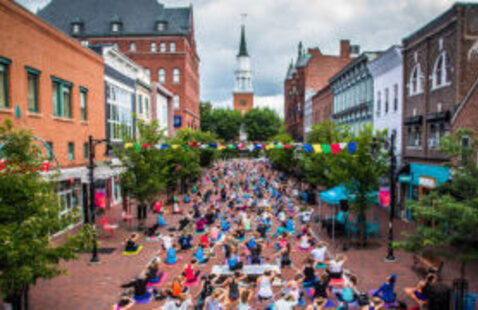 A crowd lines Church Street to participate in an outdoor yoga event.