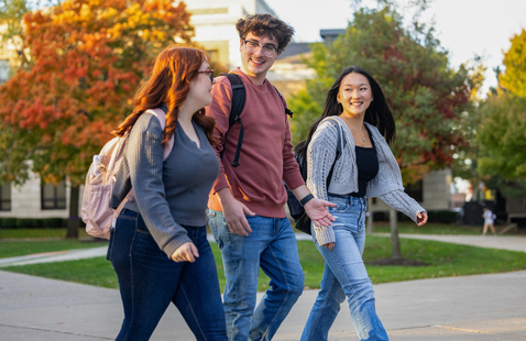 students walking outside and smiling