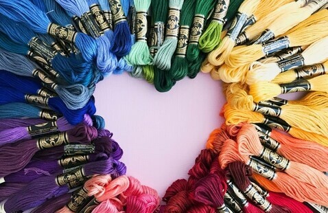 A heart-shaped outline created by multiple colors of embroidery floss