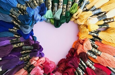 A heart-shaped outline created by multiple colors of embroidery floss