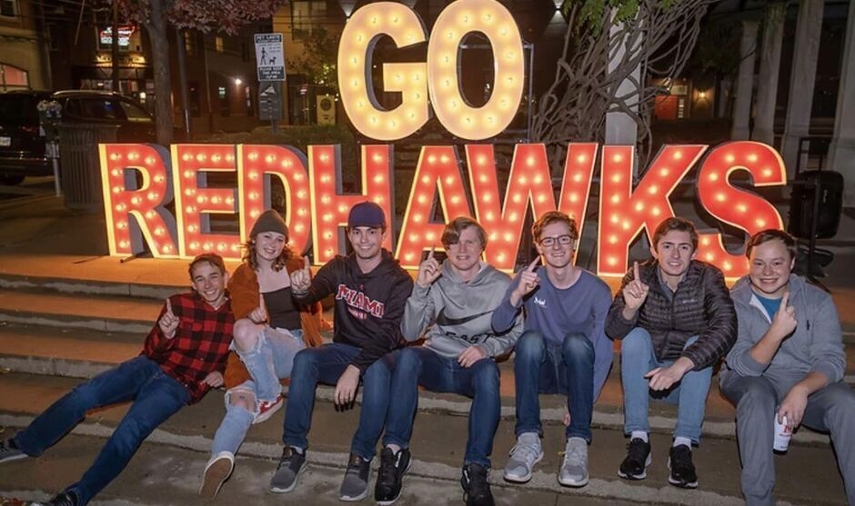 Group of students in front of a "Go RedHawks" sign