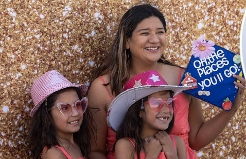 A CNM graduate and her children smile for a camera