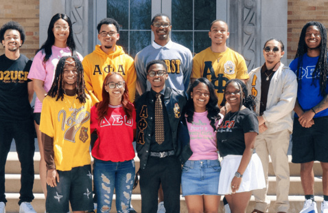 a group of students smiling on the university staircase