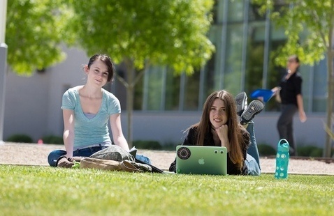 Two females sitting on the grass in the Spring 