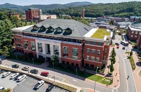 An aerial view of Reich College of Education. The Appalachian Mountains are seen in the distance behind the building.