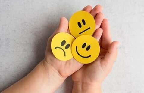Child's hands holding yellow smiley face buttons