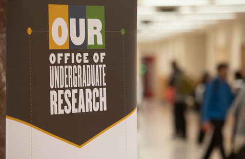 Image of a sign at a conference featuring the Office of Undergraduate Research's graphic design.