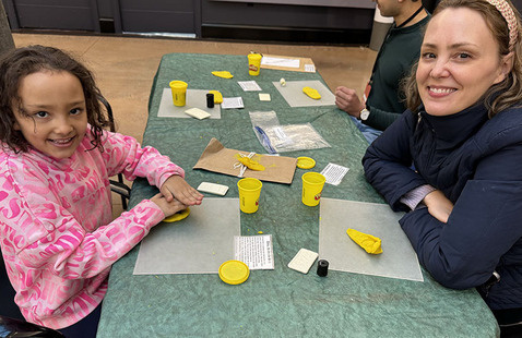 Family sitting at a table doing an activity with clay.