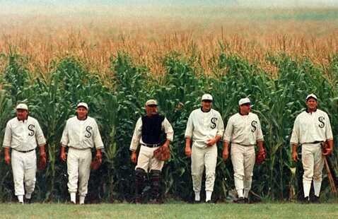baseball players walking out of a cornfield