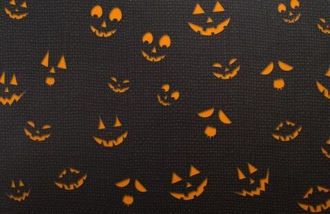 a bunch of pumpkin faces on a black background