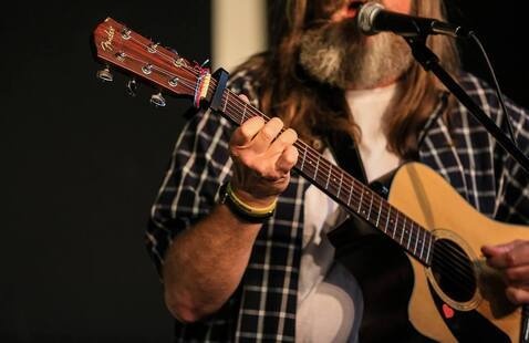 Photograph of a man playing guitar.