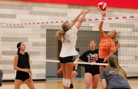 Students playing indoor volleyball