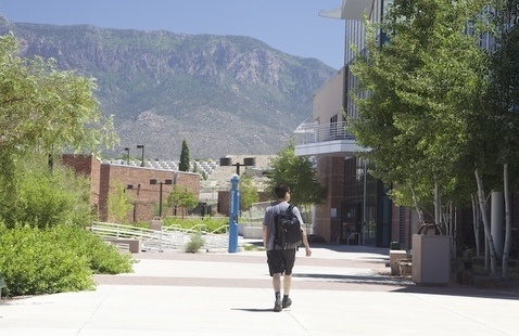 Male student walks outside between Montoya Campus buildings
