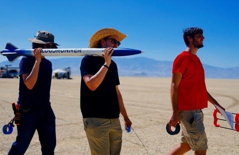 Students carry a rocket on their shoulders to test in the Nevada desert