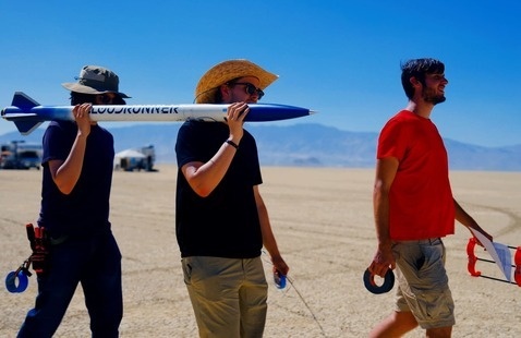 Students carry a rocket on their shoulders to test in the Nevada desert