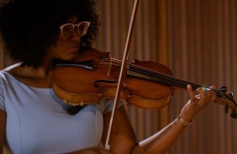 Student plays violin in a lavender dress and glasses