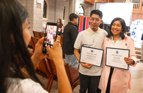 Student celebrates with family and certificate after induction into Tri-Alpha