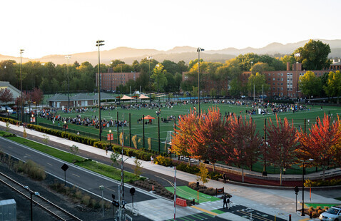 A Rec Sports Employee talks to a student about intramurals at Student Legacy Park.