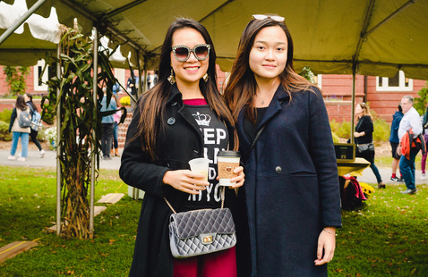 Fall Fest attendees pose together, one holding a cup of coffee.