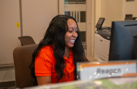 A female resident advisor talking to other students within the resident hall 