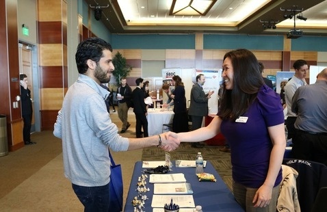 Student and prospective employer shaking hands at career fair
