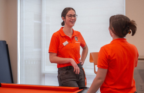 A resident advisor talking to other students within the resident hall 