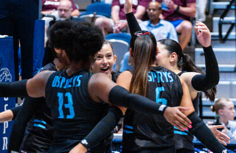 Volley ball team in a group hug at game