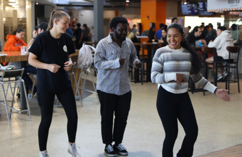 a photo of inside the social house and students dancing to music