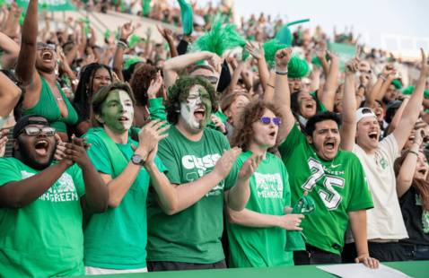 UNT fans standing in the bleachers, cheering on the players