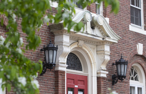 A brick building with an exterior red door. 