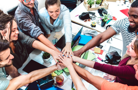 group of people with their hands in the middle like a team