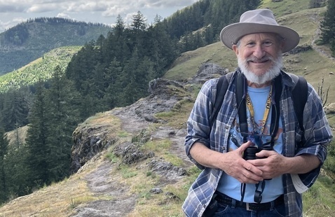Dr. Aaron Liston wearing hiking clothes on a mountainside.