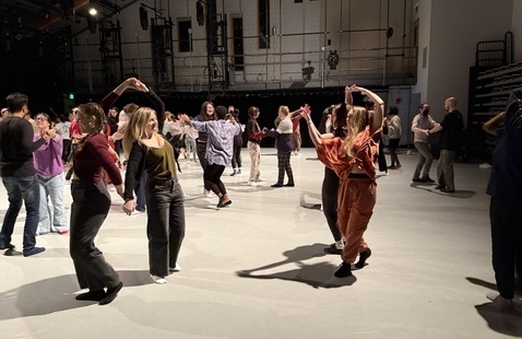 Diverse participants partnering each other joyfully in Studio 1.