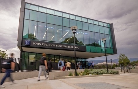 John Tulloch Business Building with students and gray skies