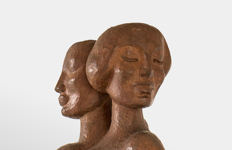 Two serene women's heads, carved out of shining wood.