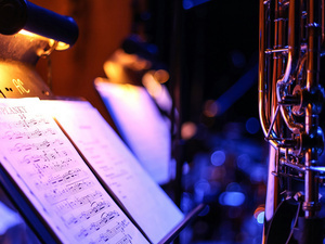 heet music on a stand, lit by a stand light.