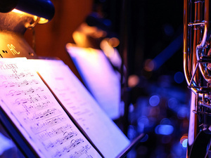 sheet music on a stand, lit by a stand light.