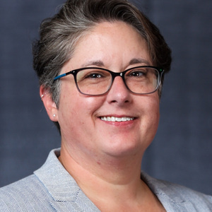 Nicole Wilson, short hair, glasses, smile, light colored blazer