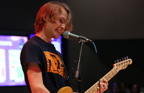 a guy singing and playing the guitar
