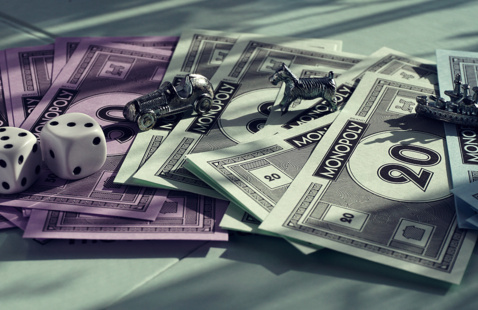 Monopoly money, game pieces and dice. 