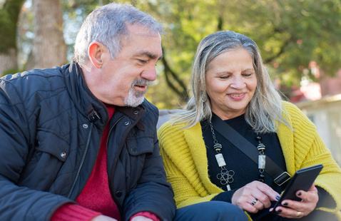 two senior citizens looking at a tablet