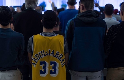 person wearing Abdul-Jabbar jersey listening to lecture by Abdul-Jabbar.