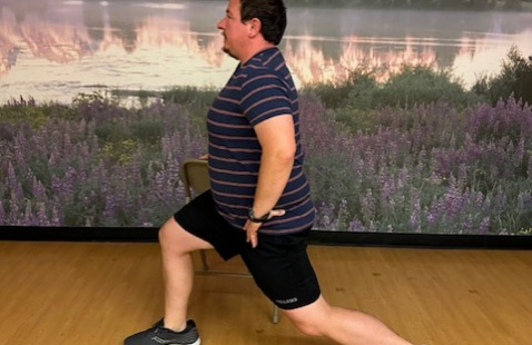 The person in a short and t-shirt is doing stretching exercise