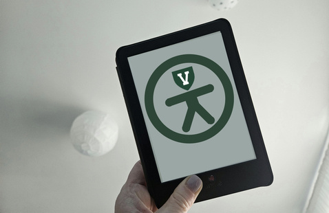 A hand holding a kindle-style tablet. On screen is a modified accessibility logo.