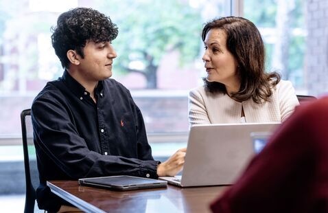 Leadership student talks with professor during class