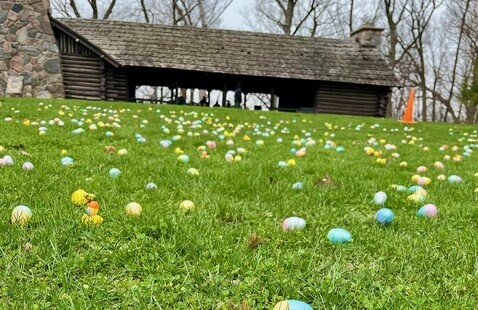 Plastic Easter Eggs on the grass in front of the CCC Shelter at Pokagon State Park.